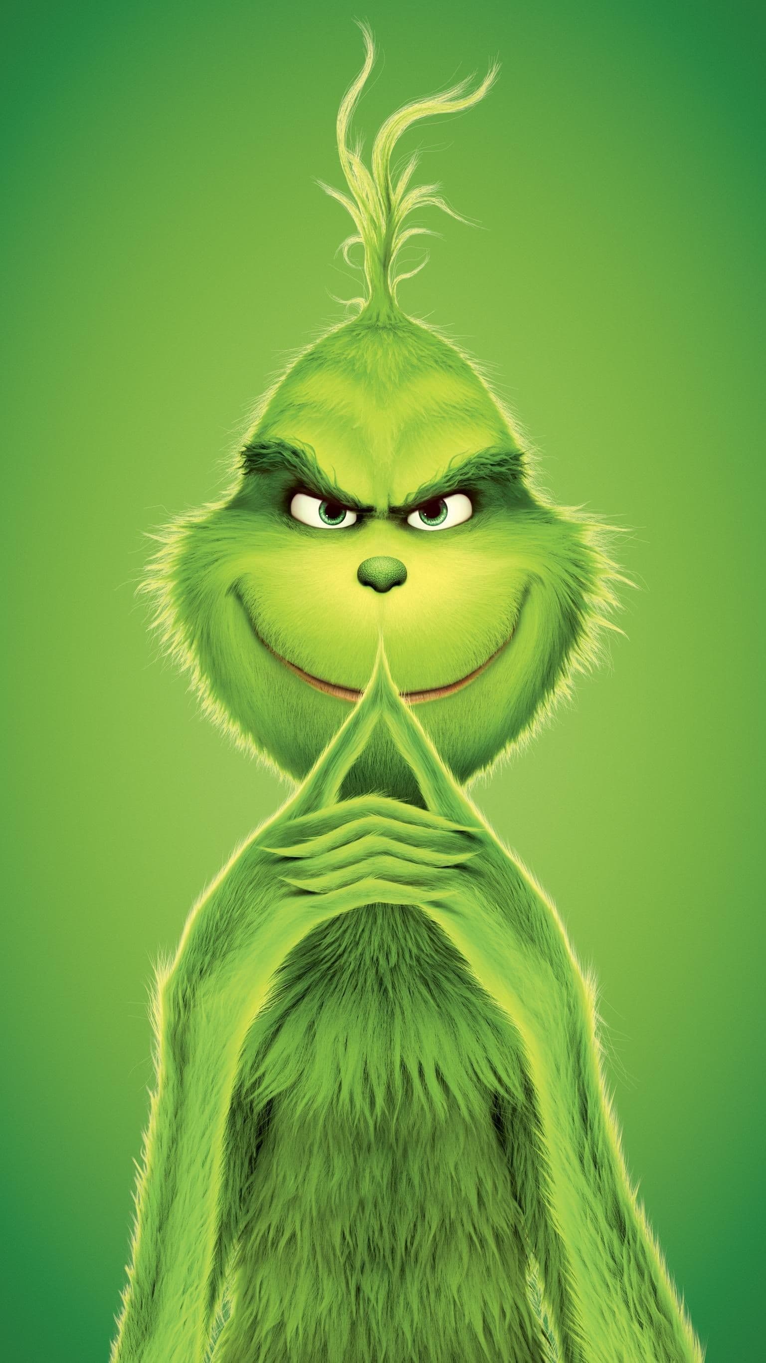 The Grinch smiling mischievously with his fingers steepled together